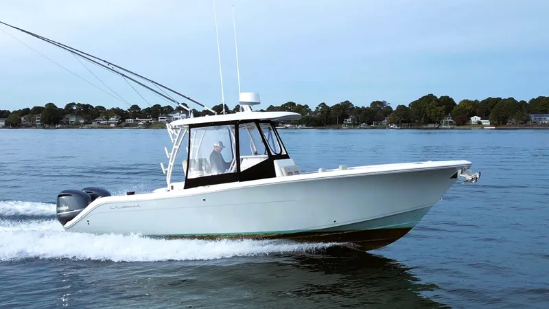 Slide: The Image of 2016 Cobia 296 Center Console boat cruising on calm water. - 3