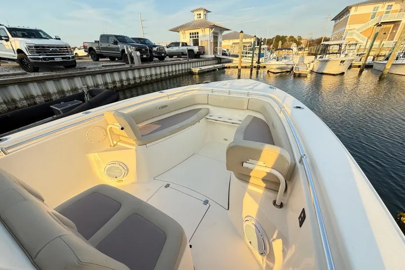 Slide: The Image of 2016 Cobia 296 Center Console boat docked at marina with seating area. - 33