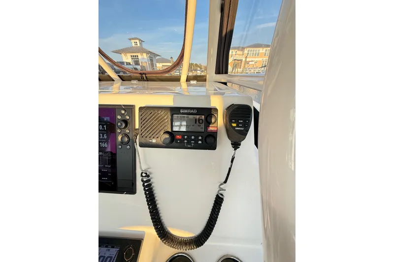 Slide: The Image of 2016 Cobia 296 Center Console boat dashboard with Simrad marine radio. - 36