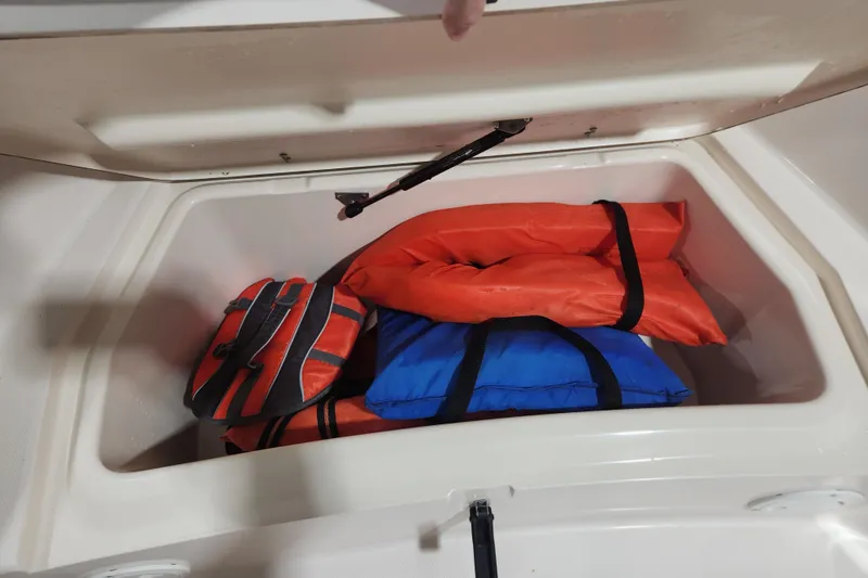 Slide: The Image of Storage compartment of a 1999 Grady-White Sportsman 180 with life jackets inside. - 6