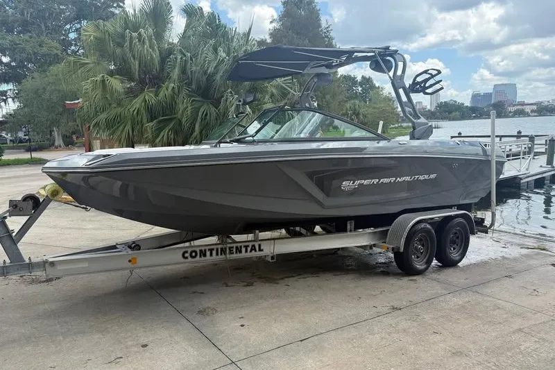 Slide: The Image of 2018 Nautique Super Air Nautique GS22 boat on trailer by lakeside. - 0