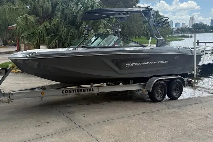 Slide: The Image of 2018 Nautique Super Air Nautique GS22 boat on trailer by lakeside. - 1
