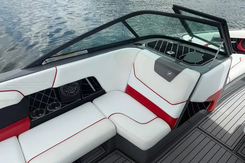 Slide: The Image of 2018 Nautique Super Air Nautique GS22 interior with white and red seating, on water. - 11
