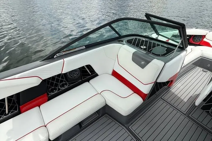 Slide: The Image of 2018 Nautique Super Air Nautique GS22 interior with white and red seating on water. - 13