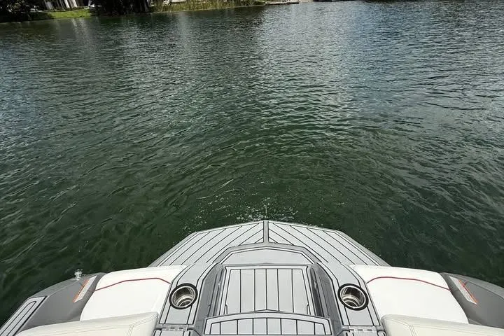 Slide: The Image of 2018 Nautique Super Air Nautique GS22 on calm water, rear deck view. - 14