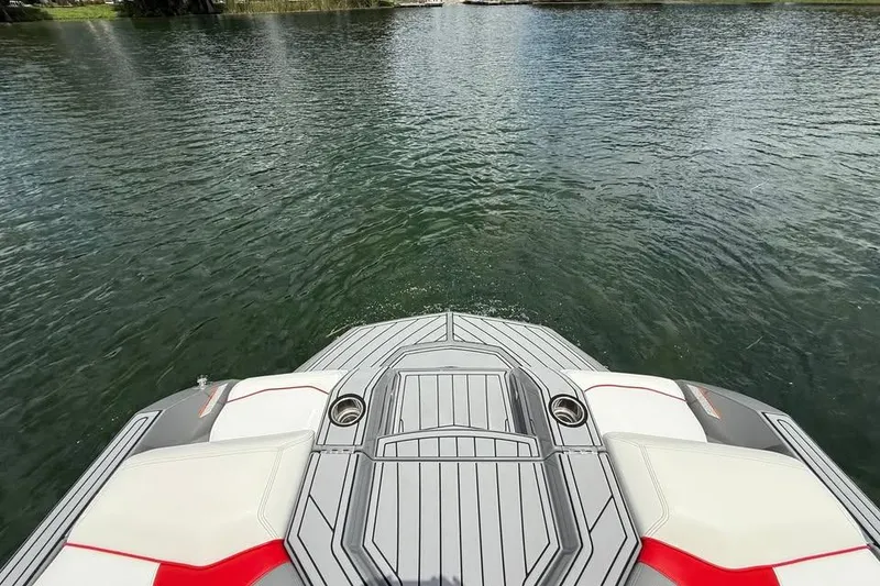 Slide: The Image of 2018 Nautique Super Air Nautique GS22 on calm water, showcasing rear deck design. - 15