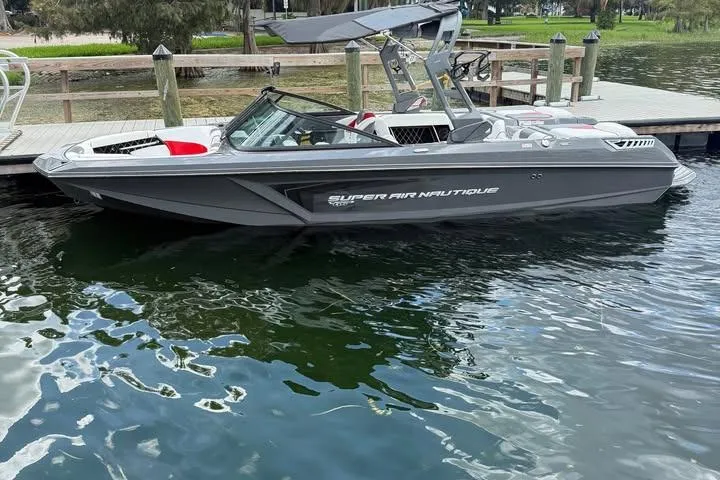 Slide: The Image of 2018 Nautique Super Air Nautique GS22 boat docked on calm water. - 5