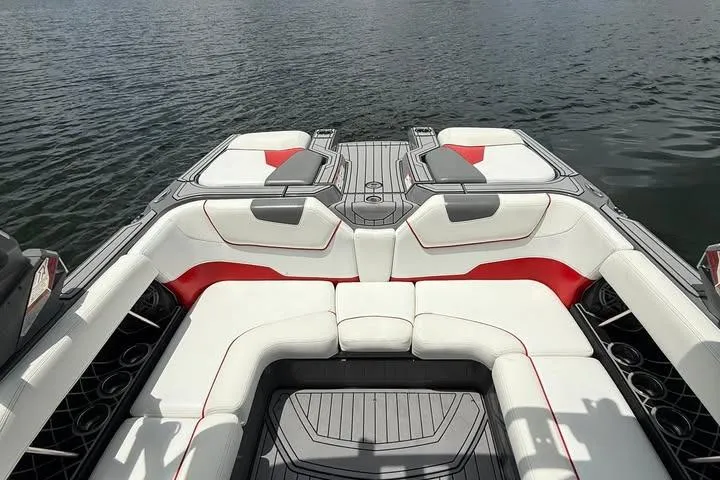 Slide: The Image of 2018 Nautique Super Air Nautique GS22 boat interior with white and red seating on water. - 8