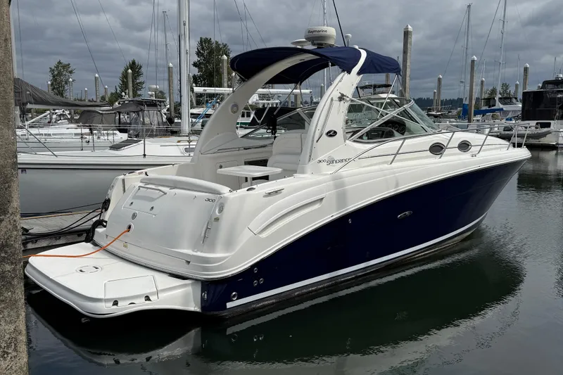 The Image of 2005 Sea Ray 300 Sundancer boat docked at marina under cloudy sky. - 0
