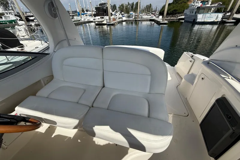 Slide: The Image of 2005 Sea Ray 300 Sundancer boat interior with white seating at marina. - 10