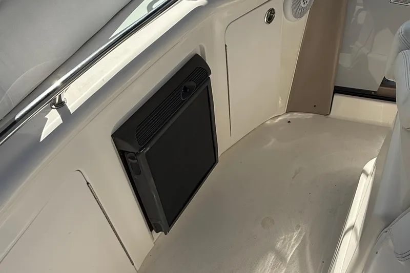 Slide: The Image of Interior of a 2005 Sea Ray 300 Sundancer boat, featuring a compact refrigerator. - 12