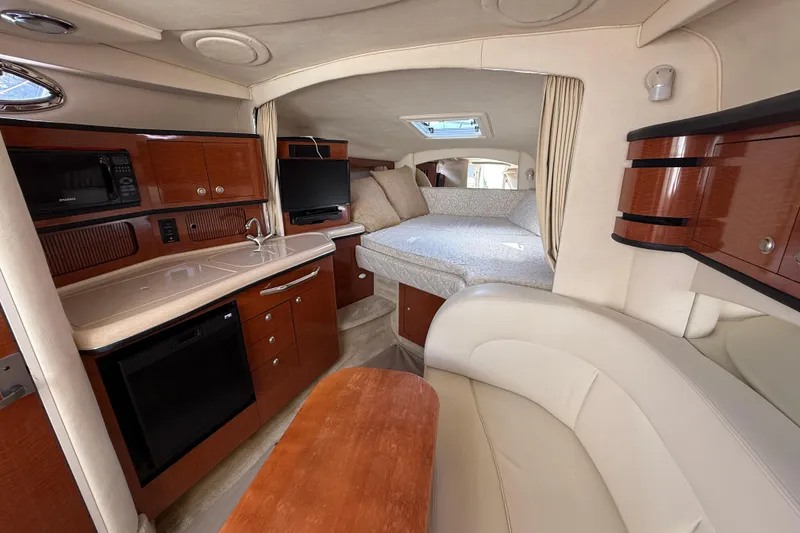 Slide: The Image of Interior of 2005 Sea Ray 300 Sundancer yacht with kitchenette and cozy sleeping area. - 13