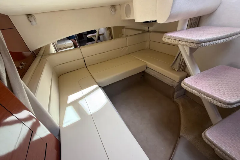 Slide: The Image of Interior of 2005 Sea Ray 300 Sundancer, featuring beige seating and carpeted steps. - 15