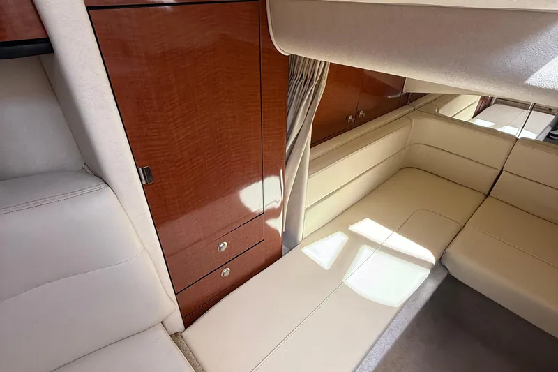 Slide: The Image of Interior of 2005 Sea Ray 300 Sundancer with beige seating and wooden cabinetry. - 17