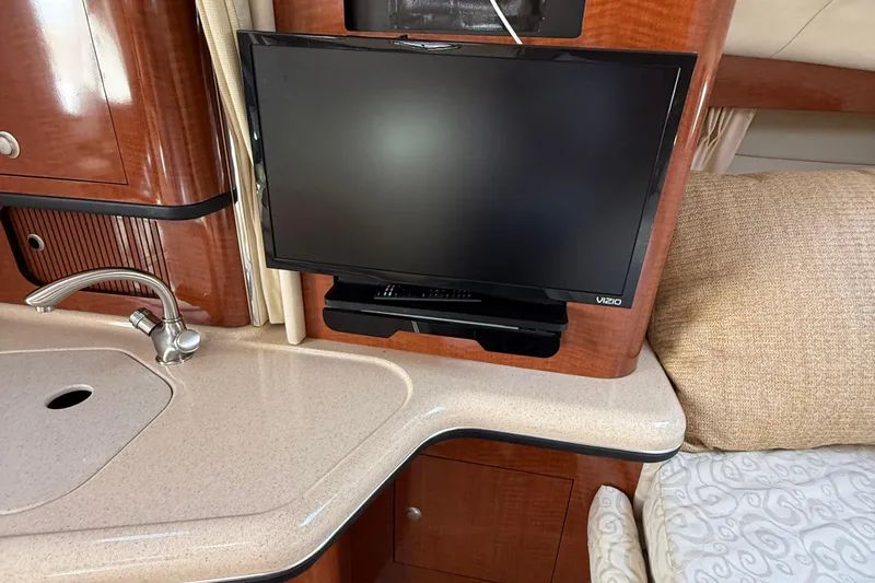 Slide: The Image of Interior of 2005 Sea Ray 300 Sundancer with TV, sink, and wooden cabinetry. - 19