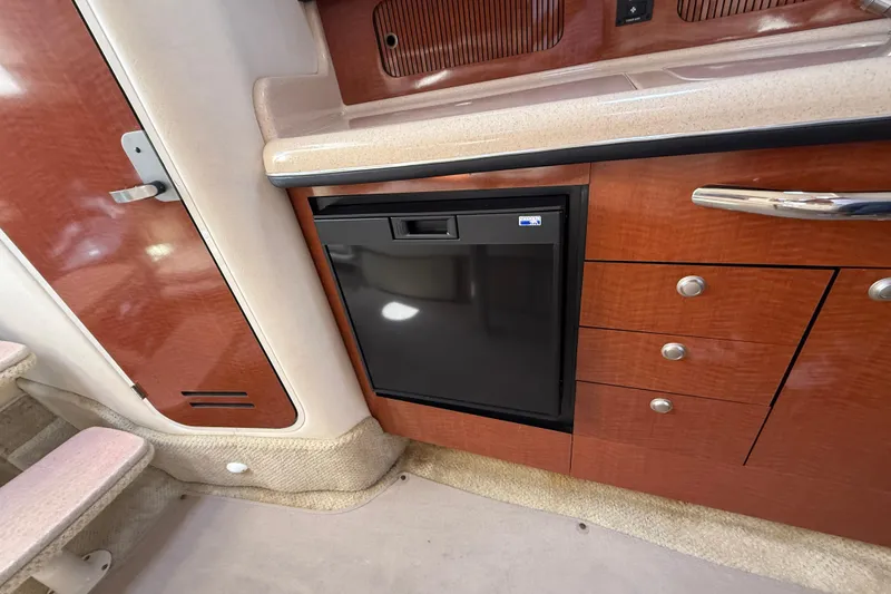Slide: The Image of Interior of 2005 Sea Ray 300 Sundancer with wood cabinetry and compact refrigerator. - 21