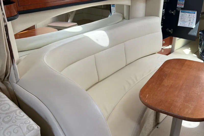 Slide: The Image of Luxurious interior of 2005 Sea Ray 300 Sundancer with cream leather seating and wooden table. - 22