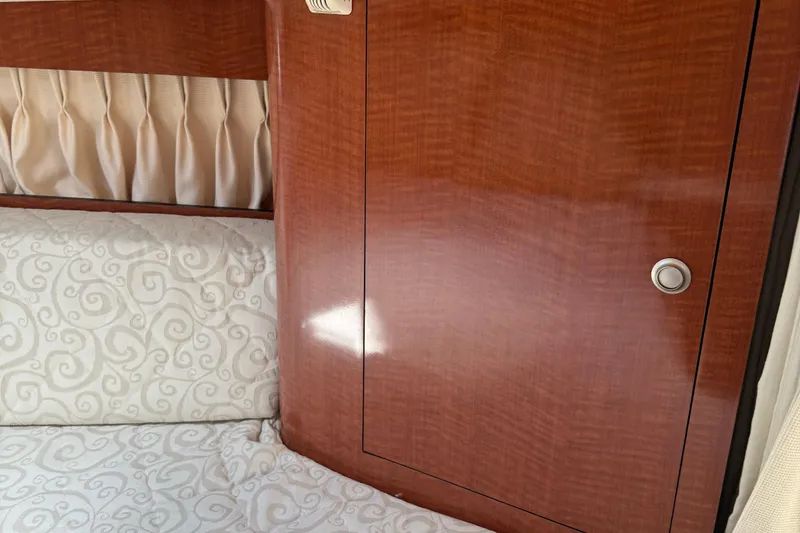 Slide: The Image of Interior cabin of 2005 Sea Ray 300 Sundancer with wood paneling and patterned bedding. - 23