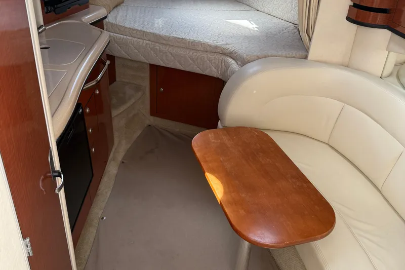 Slide: The Image of 2005 Sea Ray 300 Sundancer cabin interior with seating, table, and bed. - 25