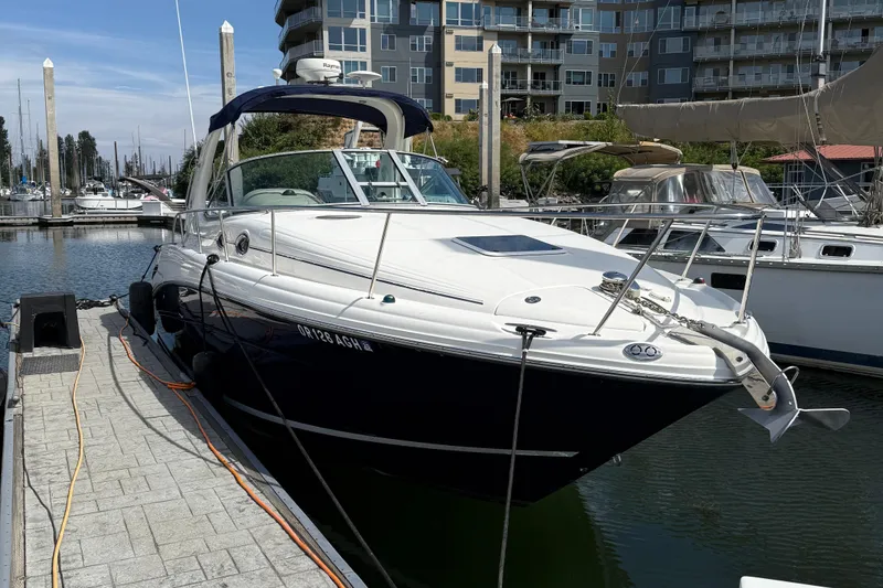 Slide: The Image of 2005 Sea Ray 300 Sundancer docked at marina with modern buildings in background. - 31