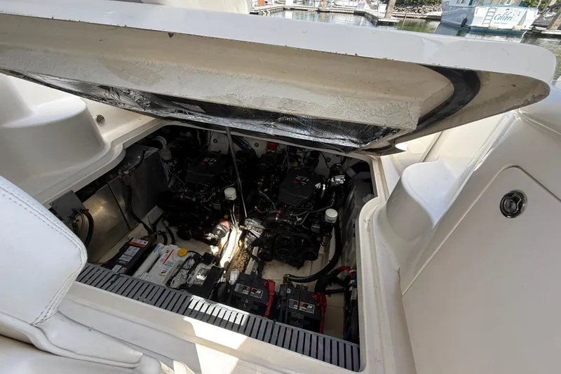 Slide: The Image of Engine compartment of 2005 Sea Ray 300 Sundancer boat, showcasing dual engines and battery setup. - 37
