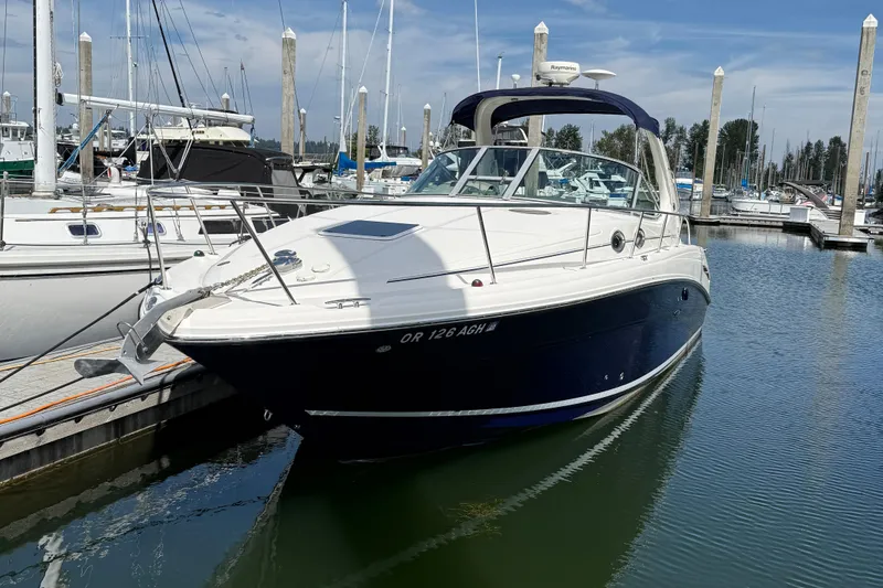 Slide: The Image of 2005 Sea Ray 300 Sundancer docked at a marina under a clear blue sky. - 4