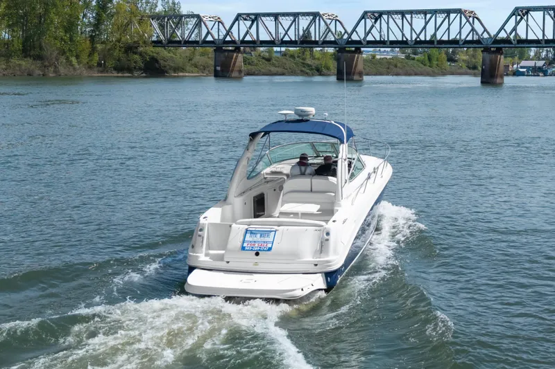 Slide: The Image of 2005 Sea Ray 300 Sundancer cruising on a river near a bridge, for sale sign visible. - 45