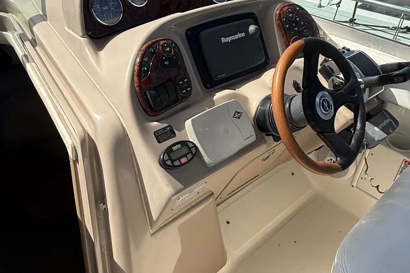 Slide: The Image of 2005 Sea Ray 300 Sundancer helm with Raymarine electronics and wood-accented steering wheel. - 5