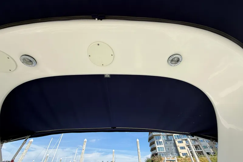 Slide: The Image of 2005 Sea Ray 300 Sundancer boat canopy with lights, marina view in background. - 6