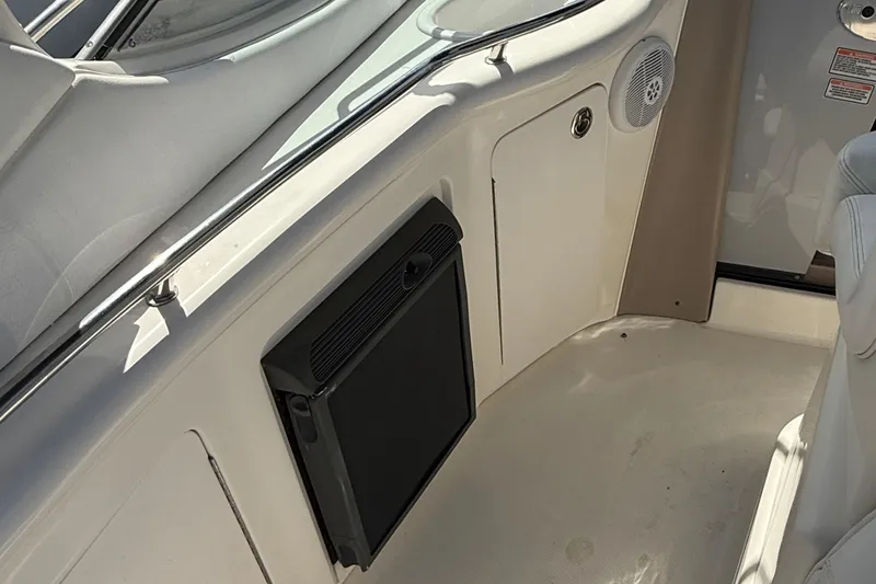Slide: The Image of Interior view of a 2005 Sea Ray 300 Sundancer boat, featuring a compact fridge. - 8