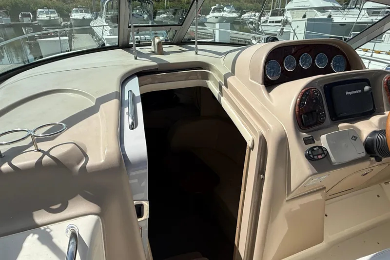 Slide: The Image of 2005 Sea Ray 300 Sundancer cockpit with navigation instruments and cabin entrance. - 9