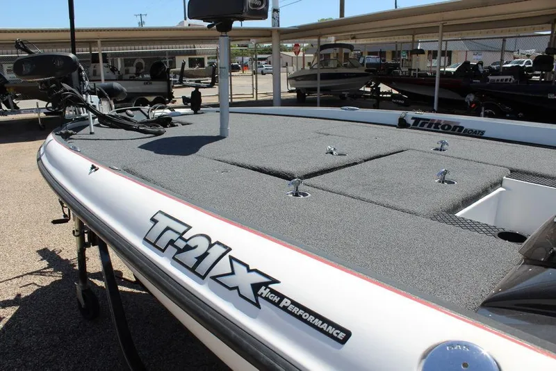 Slide: The Image of 2008 Triton Tr21 X high-performance boat with spacious deck in a showroom. - 12