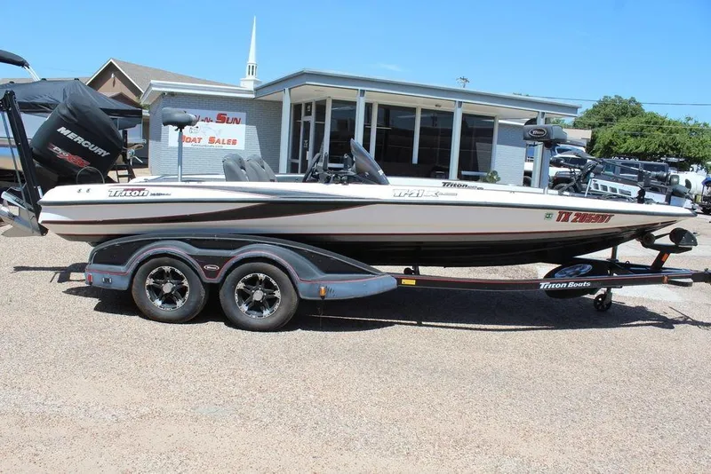 Slide: The Image of 2008 Triton Tr21 X boat with trailer, parked outside a boat sales shop. - 2