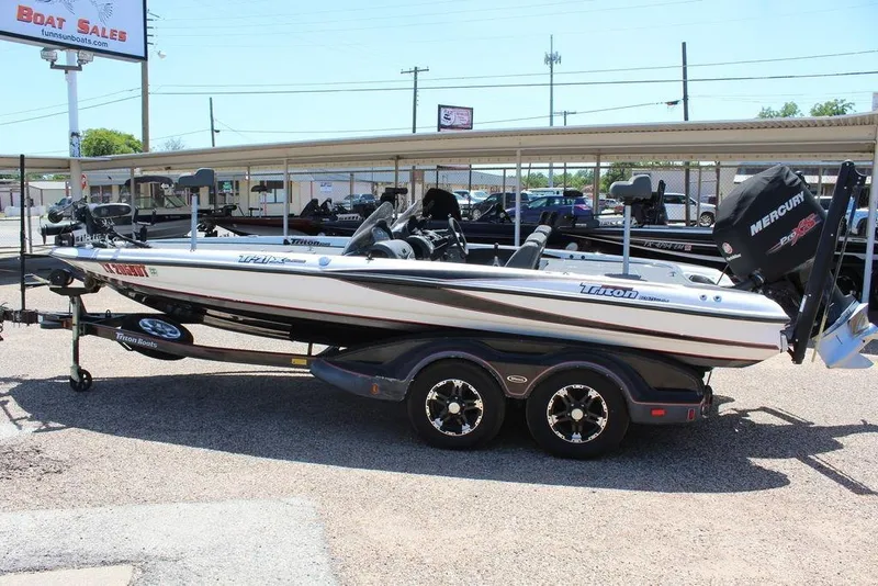 Slide: The Image of 2008 Triton Tr21 X boat on trailer at dealership, featuring Mercury engine. - 5