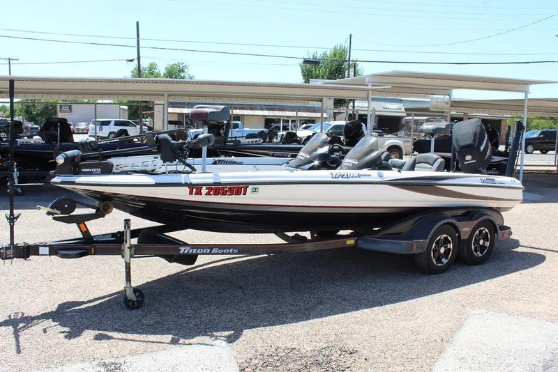 Slide: The Image of 2008 Triton Tr21 X bass boat on trailer in outdoor dealership lot. - 7
