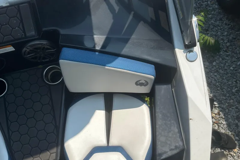Slide: The Image of 2021 Scarab 165 ID boat interior with white and blue seating, cup holders, and speakers. - 6