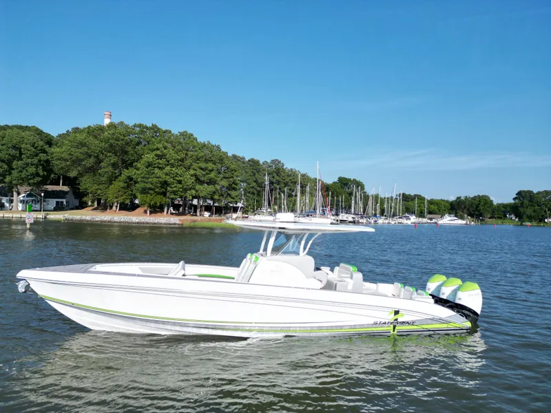 Slide: The Image of 2023 Statement 350 Open boat with triple green outboard motors on calm water. - 0
