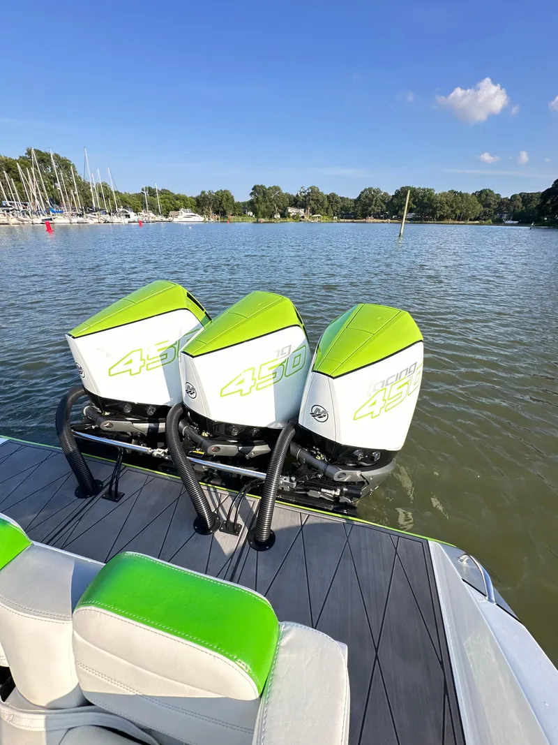 Slide: The Image of 2023 Statement 350 Open boat with triple green outboard motors on calm water. - 2