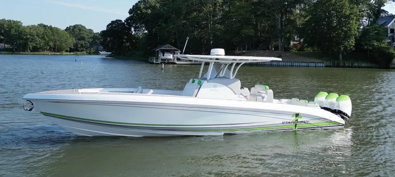 Slide: The Image of 2023 Statement 350 Open boat with vibrant green accents docked near a marina. - 5