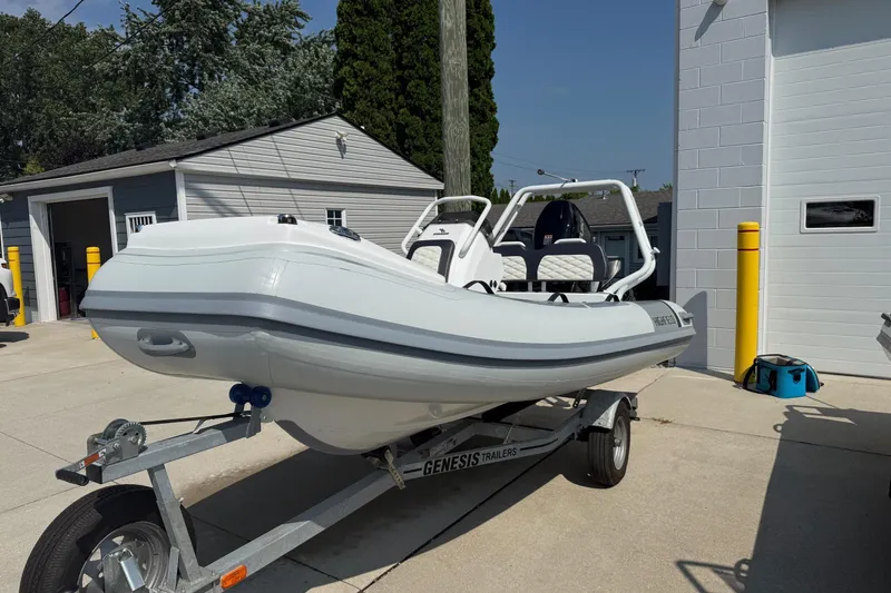 Slide: The Image of 2025 Highfield Sport 390 boat on trailer, parked outside a garage. - 8