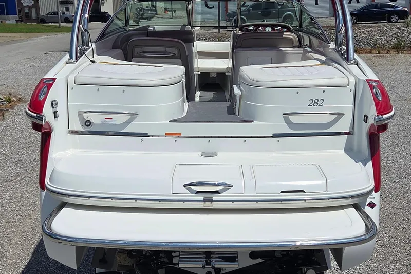 Slide: The Image of 2003 Cobalt 282 boat, rear view, white exterior, spacious seating, parked on gravel. - 3