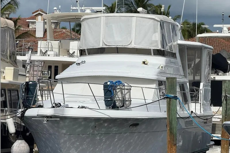 The Image of 1998 Carver 440 Aft Cabin Motor Yacht docked at marina, surrounded by other boats. - 0