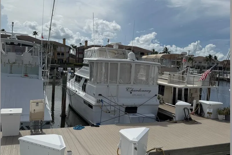Slide: The Image of 1998 Carver 440 Aft Cabin Motor Yacht docked at marina under cloudy sky. - 2