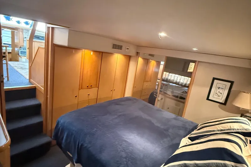 Slide: The Image of 1998 Carver 440 Aft Cabin Motor Yacht interior with cozy bedroom and wooden cabinetry. - 11