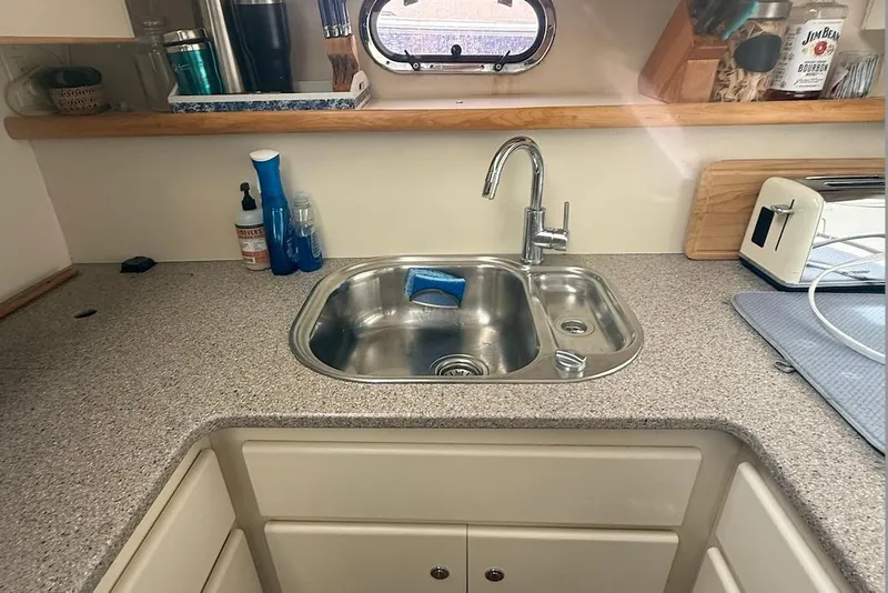 Slide: The Image of Kitchen sink area in 1998 Carver 440 Aft Cabin Motor Yacht, featuring countertop and appliances. - 12