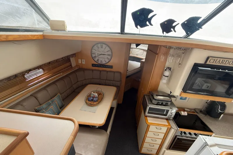 Slide: The Image of Interior of 1998 Carver 440 Aft Cabin Motor Yacht with cozy dining and kitchen area. - 6