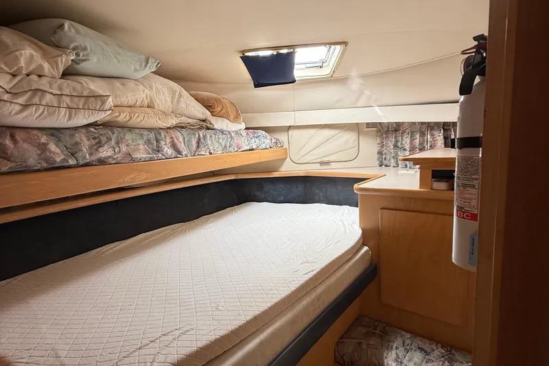 Slide: The Image of Cozy cabin interior of 1998 Carver 440 Aft Cabin Motor Yacht with bedding and fire extinguisher. - 7