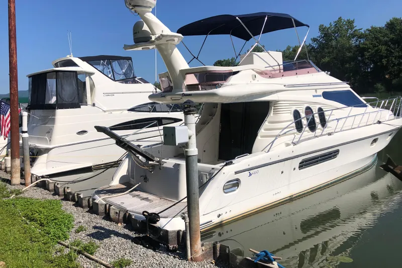 The Image of Birchwood 460 FB 2003 yacht docked beside another boat, sunny day, calm water. - 0