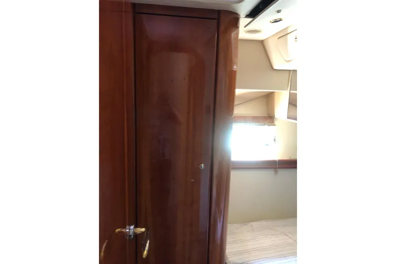 Slide: The Image of Interior of 2002 Birchwood Challenger 460 Flybridge, featuring wooden cabinetry and window. - 100