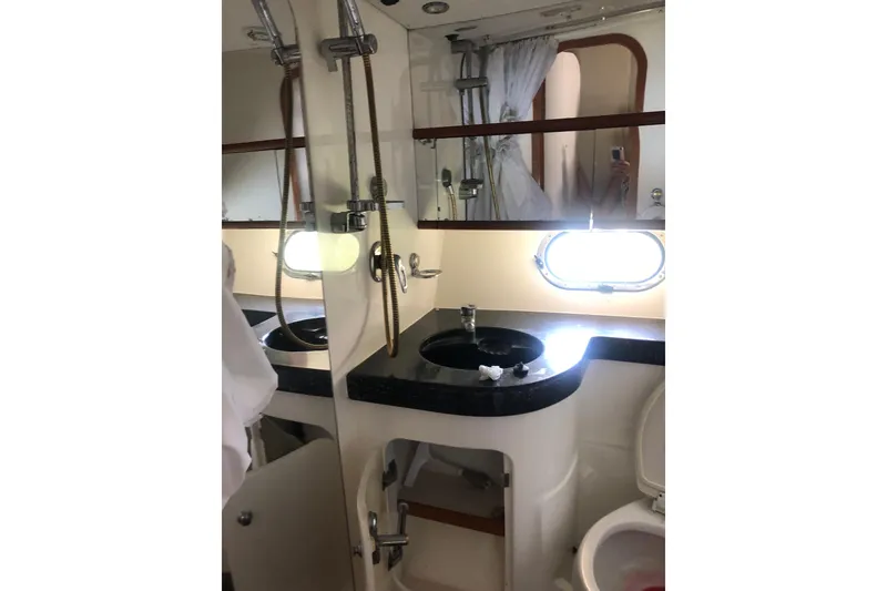 Slide: The Image of Birchwood Challenger 460 Flybridge 2002 yacht bathroom with sink, shower, and porthole window. - 103